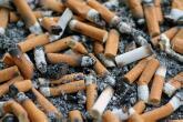 Raucher - Brennende Zigaretten Kippen im Müll